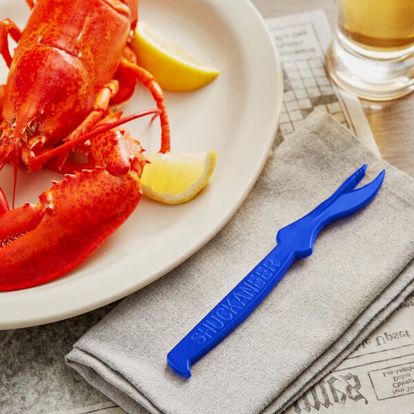 A lobster on a plate with a blue Seafood Sheller and a lemon.