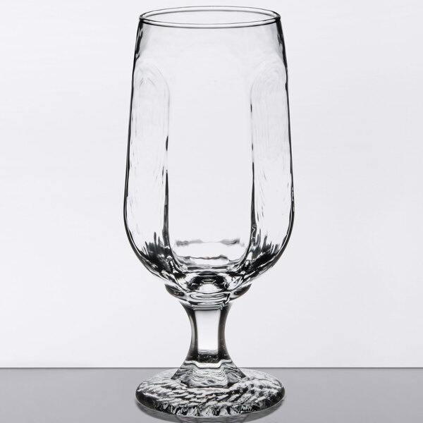 A close-up of a Libbey stemmed pilsner glass with a rim.