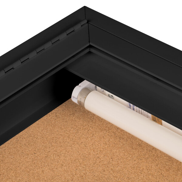 An Aarco black indoor lighted bulletin board cabinet.