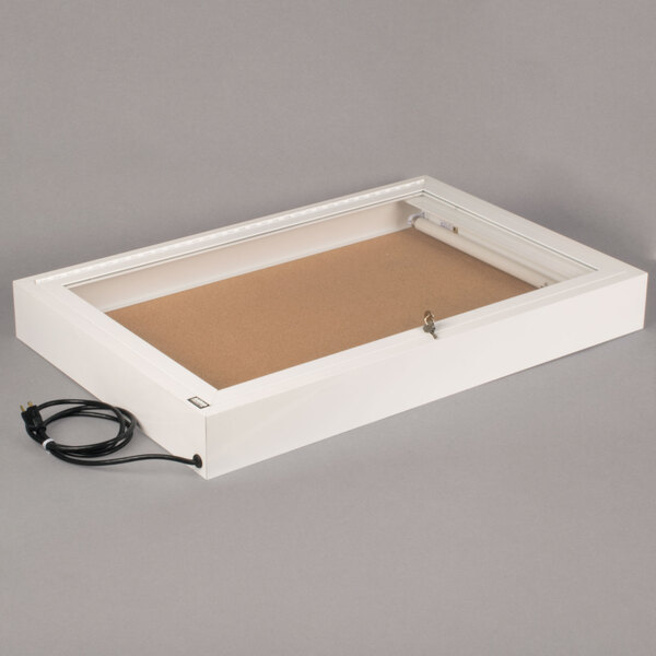 A white rectangular box with a glass door and a power cord.