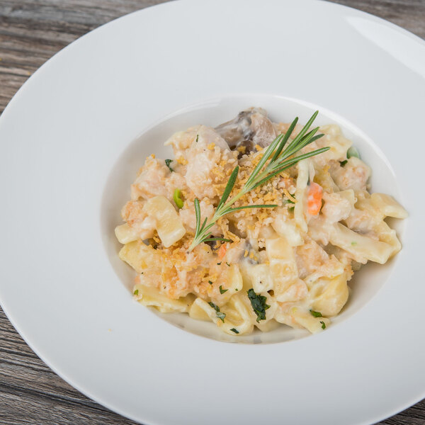 A Schonwald white porcelain bowl filled with pasta and a sprig of rosemary.