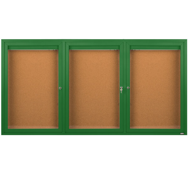 A brown rectangular cabinet with a green border and three glass doors containing cork boards.