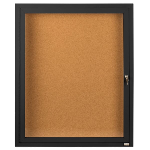 A black framed enclosed bulletin board with a glass door and key.