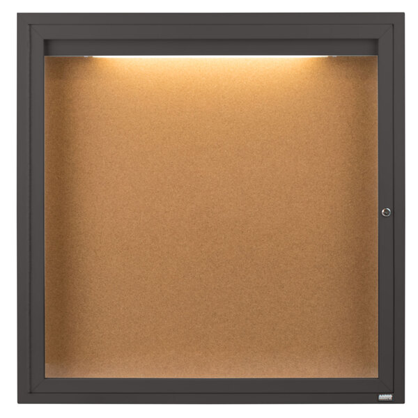 A brown cork board with a light inside.
