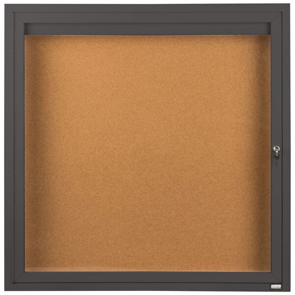 A brown enclosed bulletin board with a key lock.