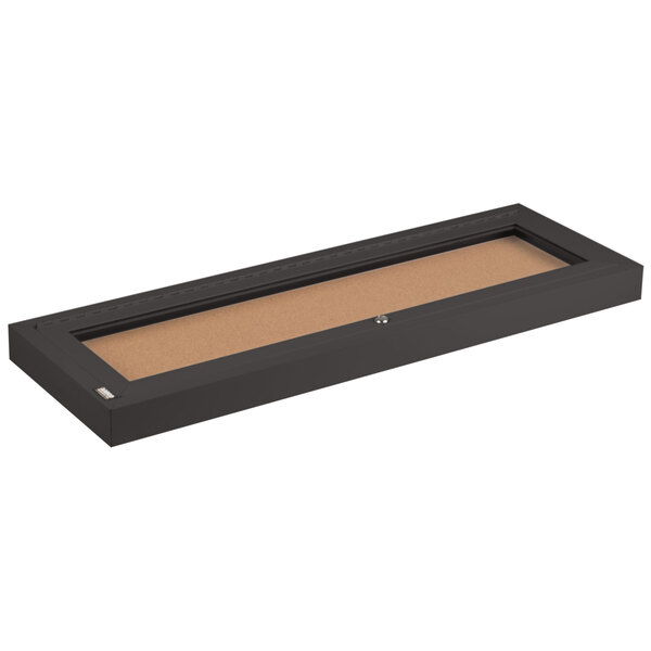 A rectangular black frame with a cork board inside.