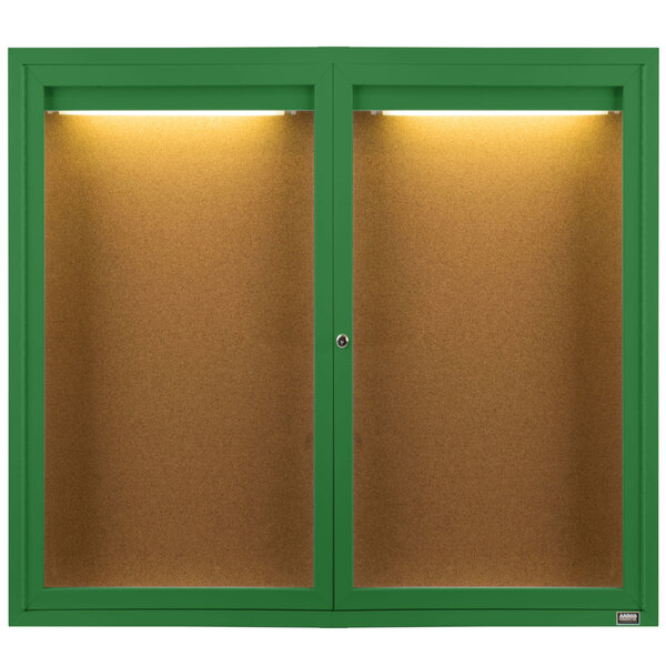 A brown surface with two green Aarco enclosed bulletin board cabinets with lights.
