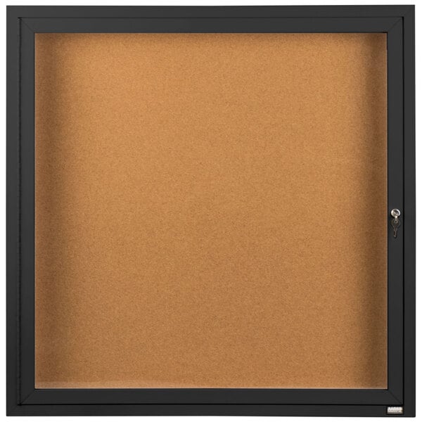 A black framed bulletin board with a key.