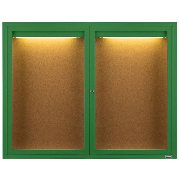 Two green Aarco enclosed bulletin board cabinets with lights.