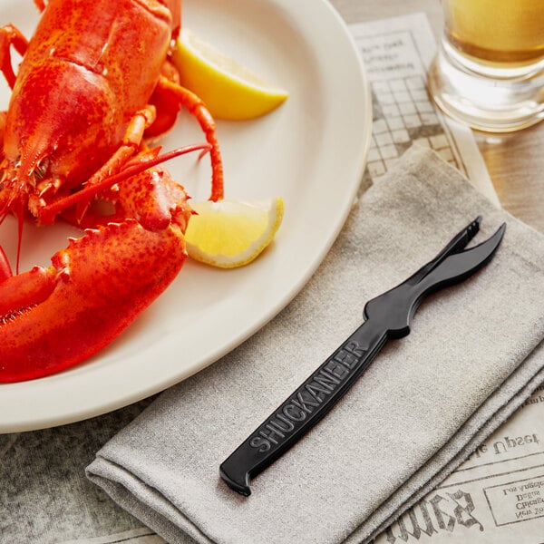 A lobster on a plate with a Choice black seafood sheller, lemon, and a knife.