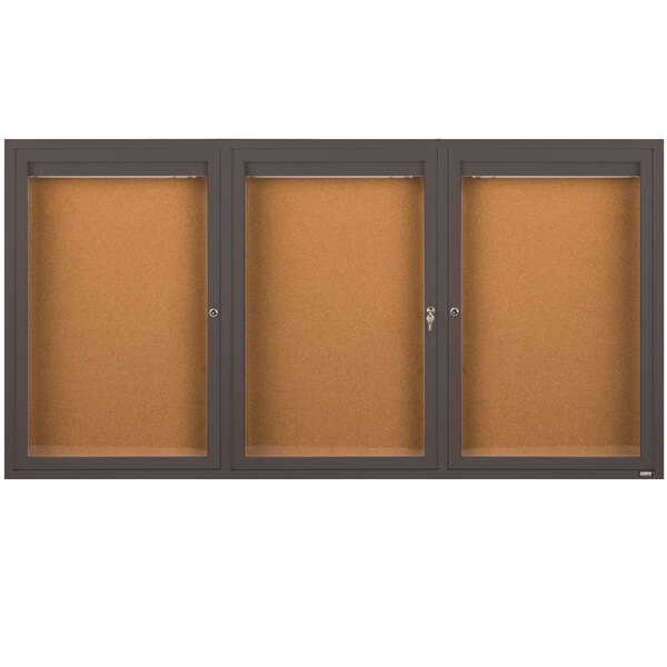 A brown rectangular Aarco bulletin board cabinet with three glass doors.
