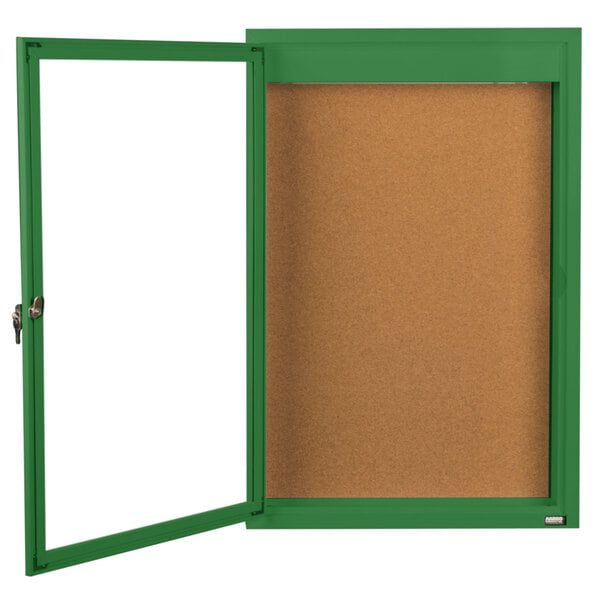 An indoor green framed bulletin board with a white background.