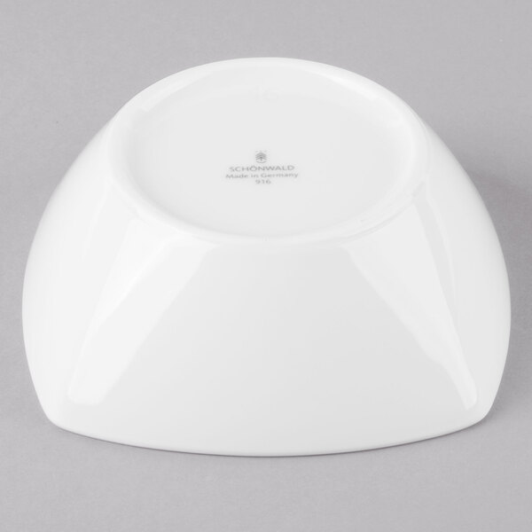 A Schonwald white porcelain low bowl on a gray background.