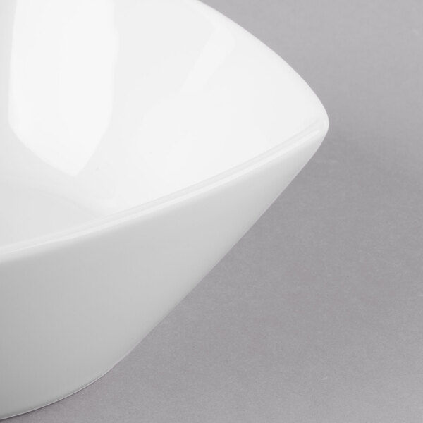 A close up of a Schonwald white square porcelain bowl with a curved edge.
