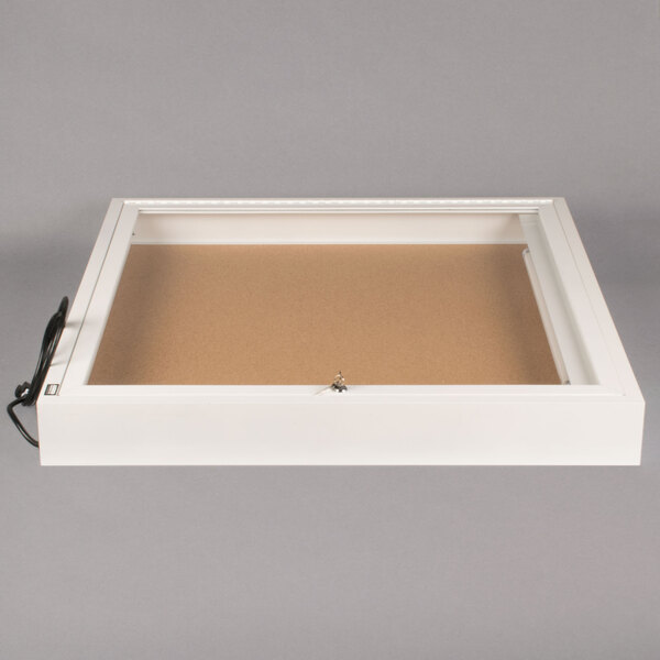 A white rectangular box with a white border and a cork board inside.