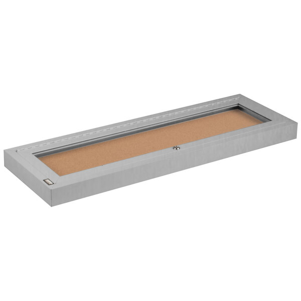 A rectangular white metal box with a cork board inside.