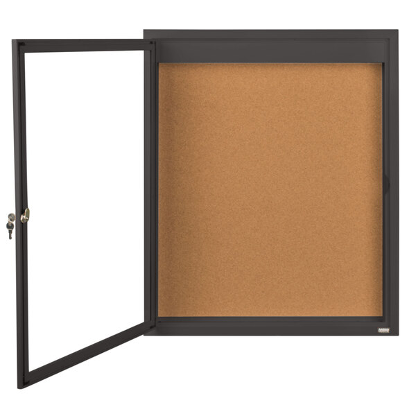 A brown cork board with a black frame and a door open.