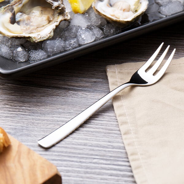 A plate of oysters with an Arcoroc Vesca stainless steel oyster fork on it.