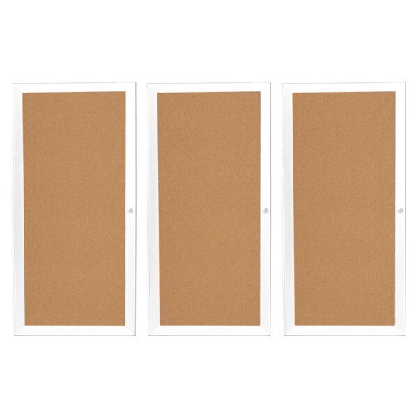 A white Aarco bulletin board cabinet with three cork board doors.