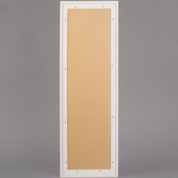 A rectangular white frame with a tan board and door.