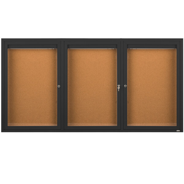 A brown rectangular bulletin board cabinet with a black border and three black doors with glass panels.