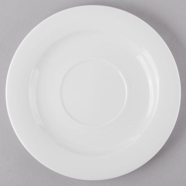 A Schonwald white porcelain tapas plate with a white rim on a gray surface.