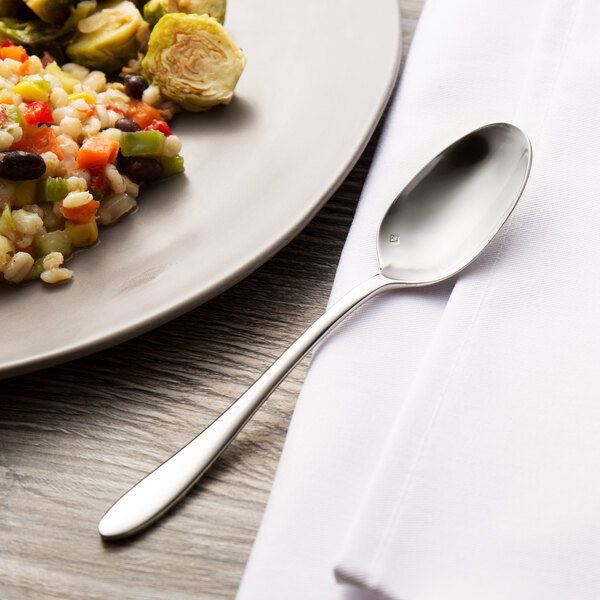 A plate of food with a Chef & Sommelier stainless steel teaspoon on it.