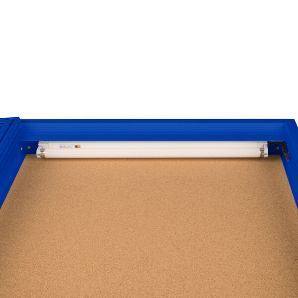 An Aarco blue indoor lighted bulletin board cabinet with one door.
