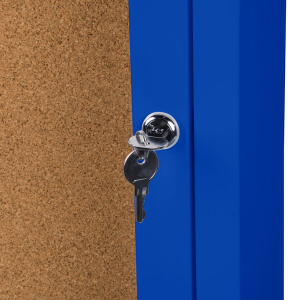 An Aarco blue indoor bulletin board cabinet with a key in the lock.