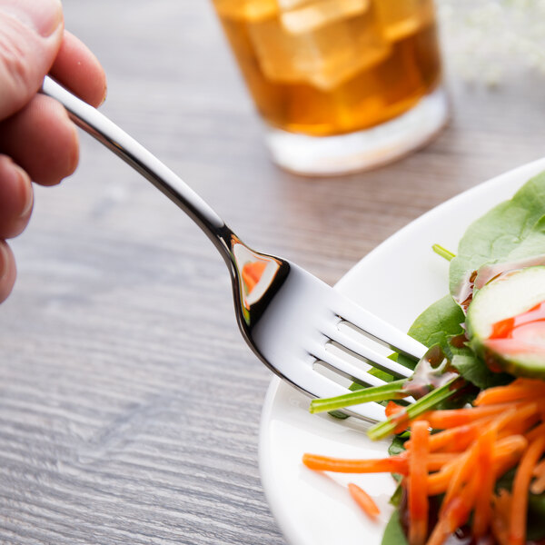 A Chef & Sommelier Lazzo stainless steel salad fork on a plate of salad.