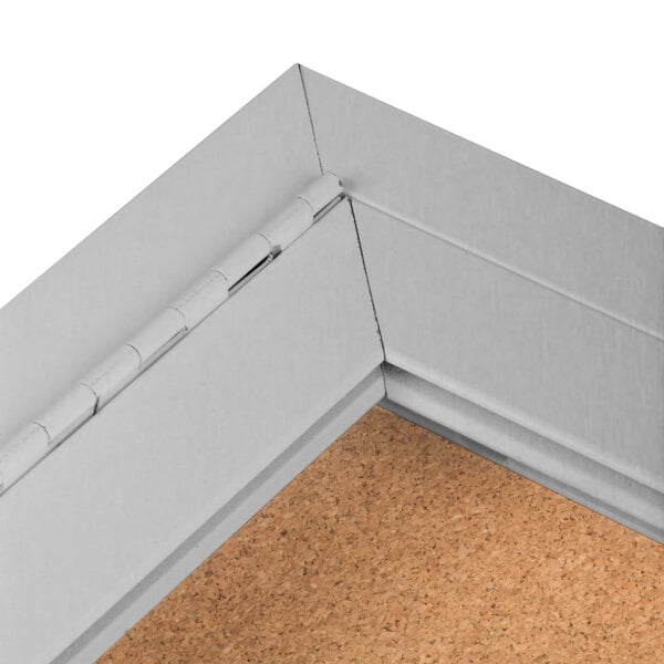 An Aarco satin anodized indoor bulletin board cabinet with a cork board inside.