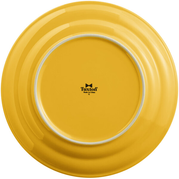 A yellow Tuxton Concentrix China plate with a white rim.