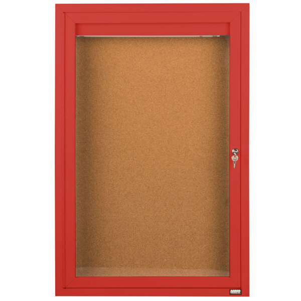 A red Aarco indoor enclosed bulletin board cabinet with a glass door and key.