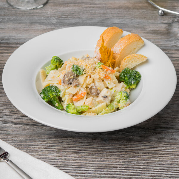 A Schonwald white porcelain soup bowl filled with pasta and broccoli.