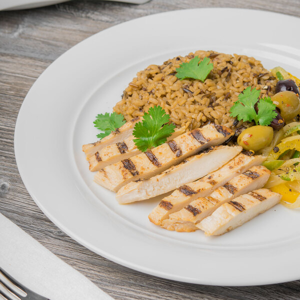A Schonwald Avanti Gusto porcelain plate with grilled chicken and rice on it on a table.