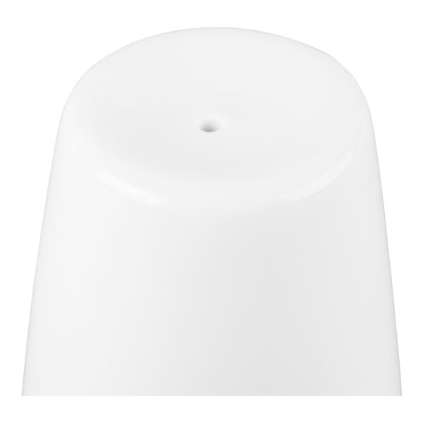 A white, smooth, cylindrical object with a single small hole on top, likely a close-up of a pepper shaker.