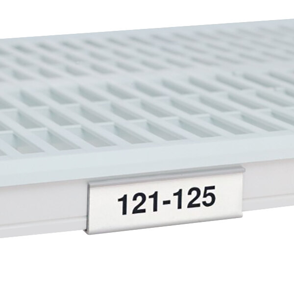 A white plastic MetroMax i label holder with black numbers on a white surface.