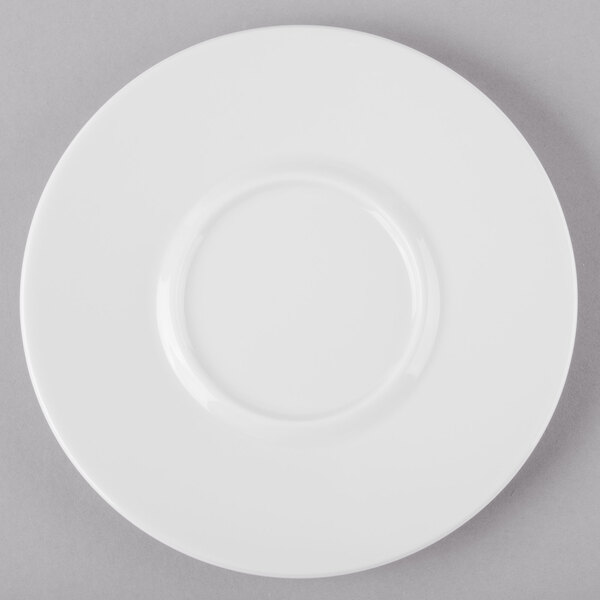 A Schonwald white porcelain saucer with a circular edge on a gray surface.