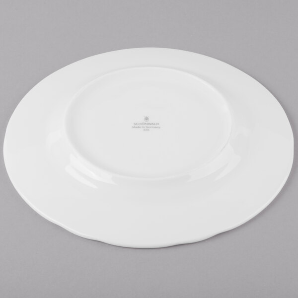A Schonwald Marquis white porcelain plate with a small rim on a gray surface.