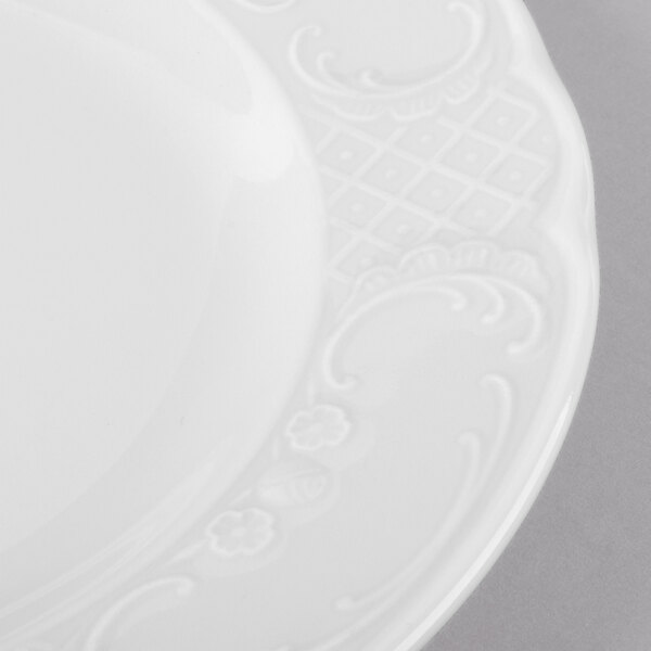 A close-up of a Schonwald white porcelain plate with a decorative design.
