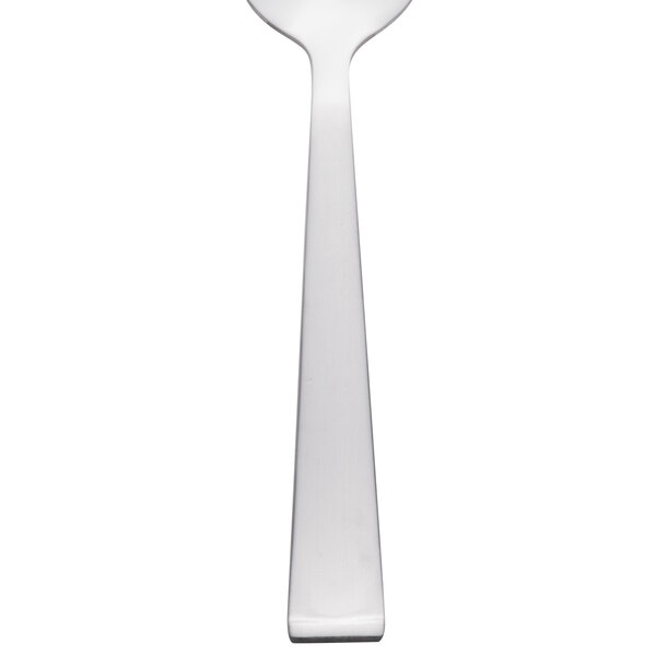 A close-up of a Libbey stainless steel teaspoon with a white handle.
