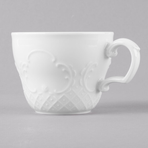 A close-up of a Schonwald white porcelain tea cup with a handle.