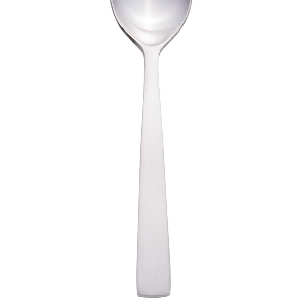 A Libbey stainless steel demitasse spoon with a white handle and silver spoon.