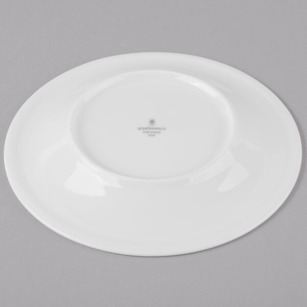 A white Schonwald Avanti Gusto porcelain saucer on a gray surface.