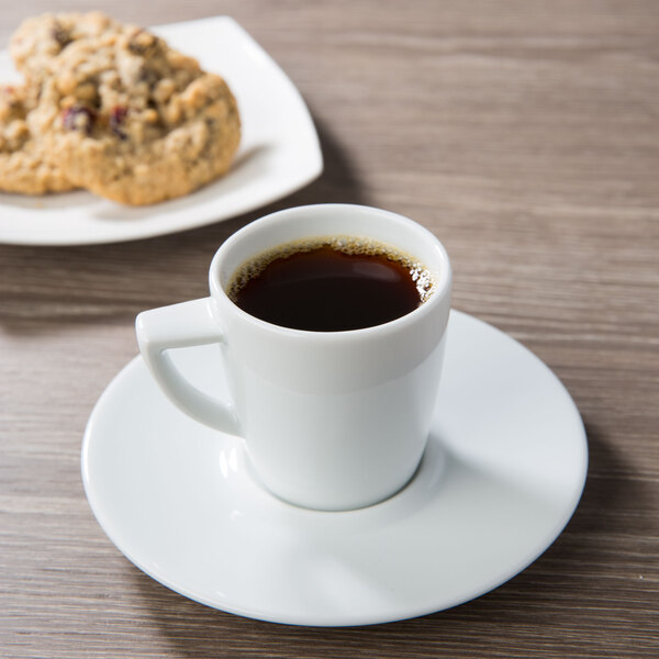 A cup of coffee on a Schonwald porcelain saucer with a cookie.
