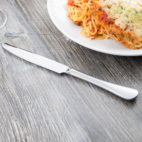 A plate of spaghetti and meatballs with a Reserve by Libbey stainless steel dinner knife on a table.