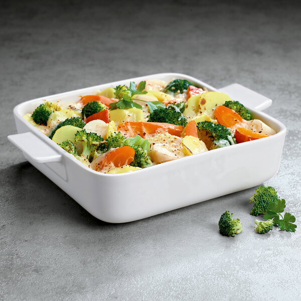 A white Villeroy & Boch square porcelain dish with a lid on top filled with vegetables.