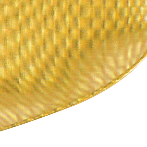 A yellow rectangular platter with a pearl design on a table with a yellow fabric with a white background.