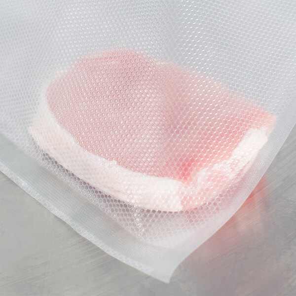 A piece of meat wrapped in a VacPak-It quart size full mesh vacuum packaging bag.