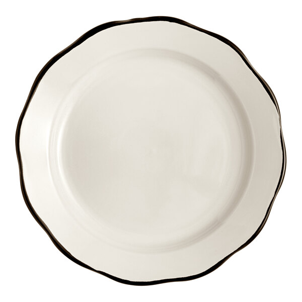 An Acopa ivory stoneware plate with scalloped edges and a black rim.